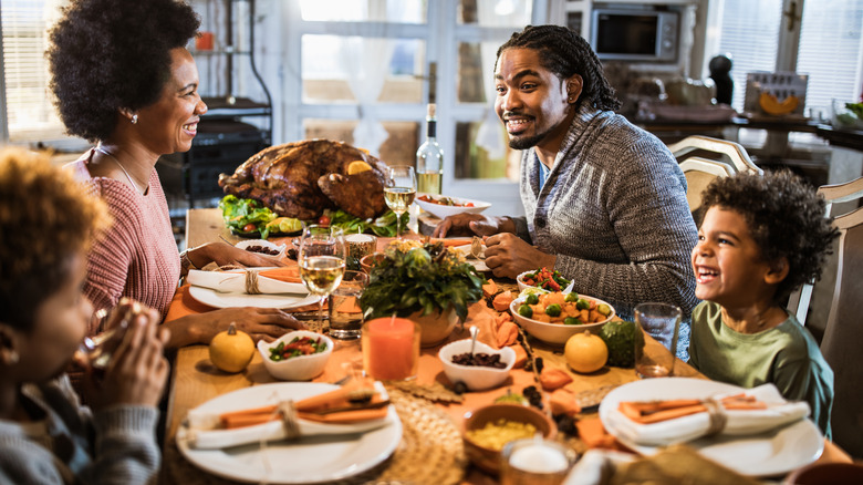 Family celebrating Thanksgiving on a dinner table