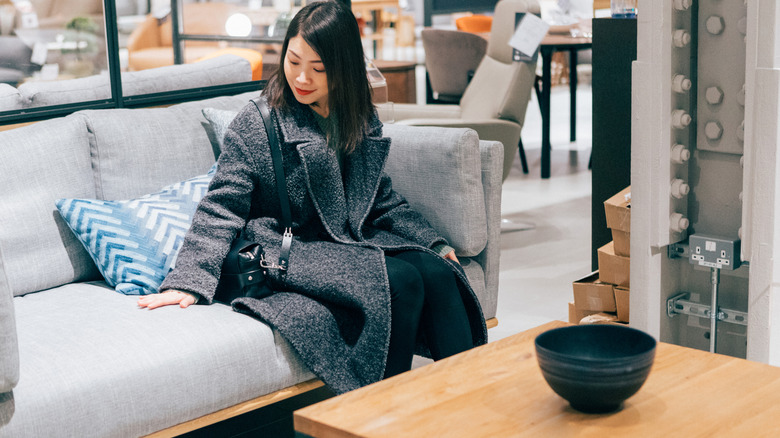 Woman testing out couch at furniture store