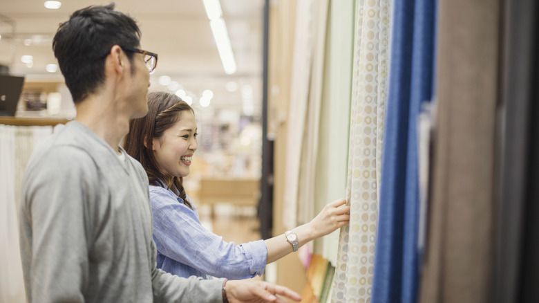 A man and woman shop for curtains