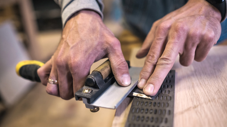 A person sharpening a chisel