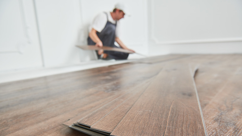 man installing vinyl plank flooring