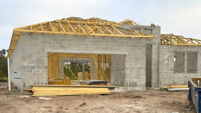 A garage under construction with block walls and a timber frame roof