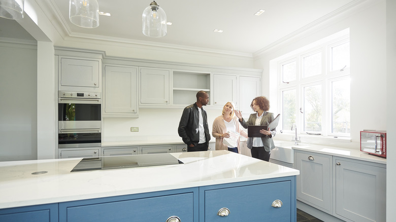 people touring new house kitchen