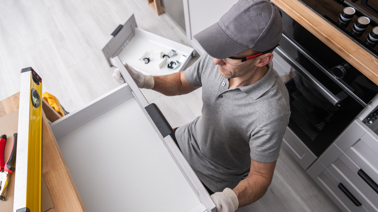 A man installing a kitchen drawer