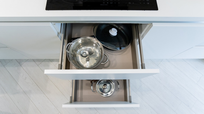 Two open pot drawers open under a cooktop