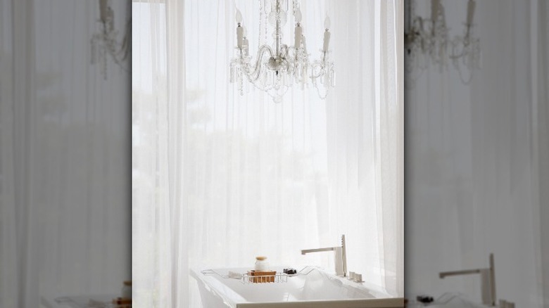 White and gray chandelier over a tub