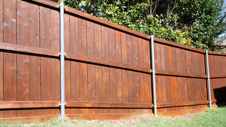 A wood fence with metal posts