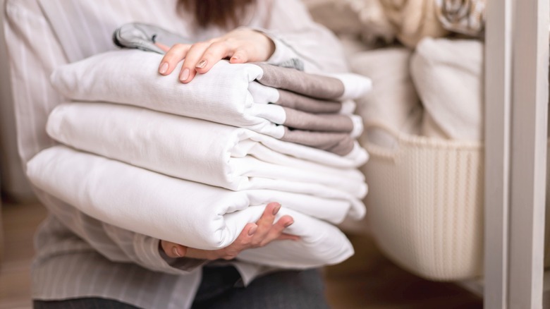 Person carrying stack of bedding