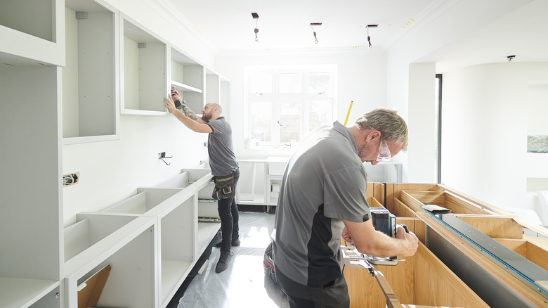 contractors installing cabinets in kitchen