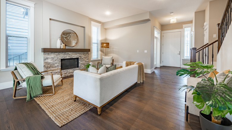 Simple living room interior with bohemian color tones and a stone fireplace.