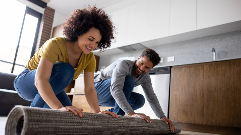 people rolling out an area rug