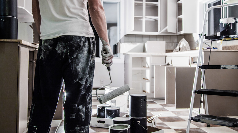 Person painting kitchen cabinets white