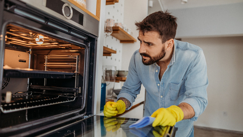 Man cleaning inside an oven