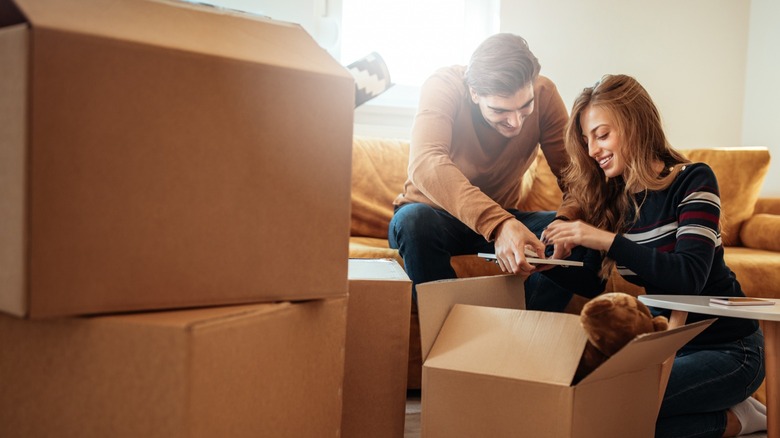 Couple packing boxes together 