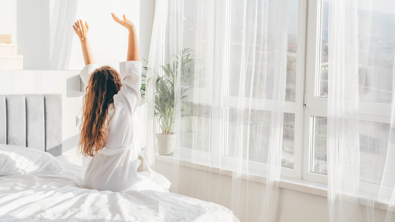 Woman stretching on bed's edge