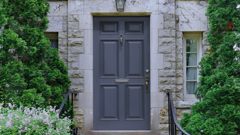 dark gray front door on stone house