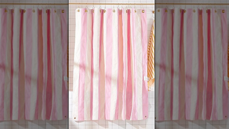 Pink-striped shower curtain hanging in front of a bathtub