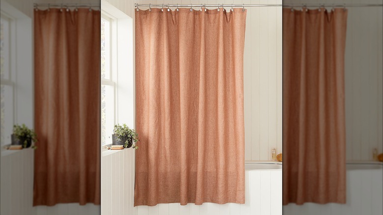 Linen shower curtain hanging in bathroom