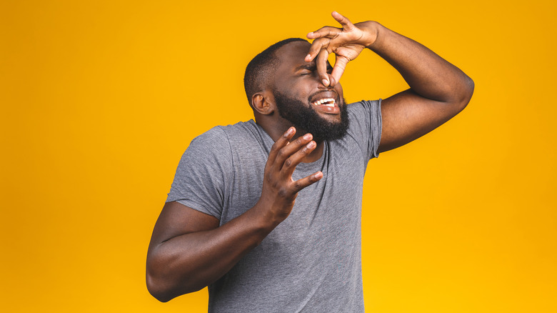 Person pinching nose blocking smell