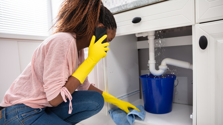 Woman dealing with leaky sink