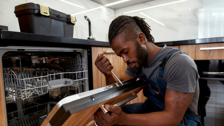 Plumber installing new dishwasher