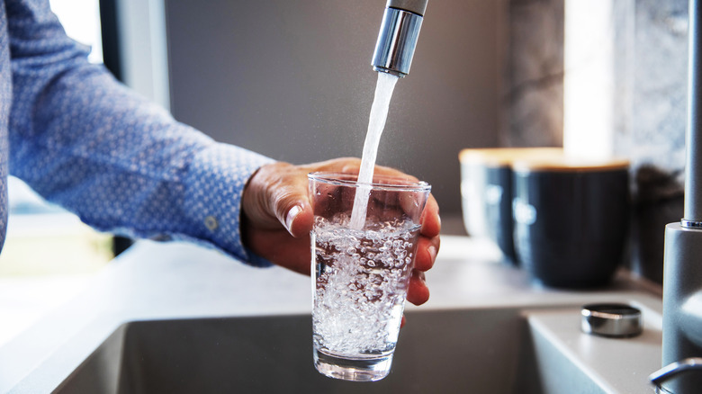 man filling water glass