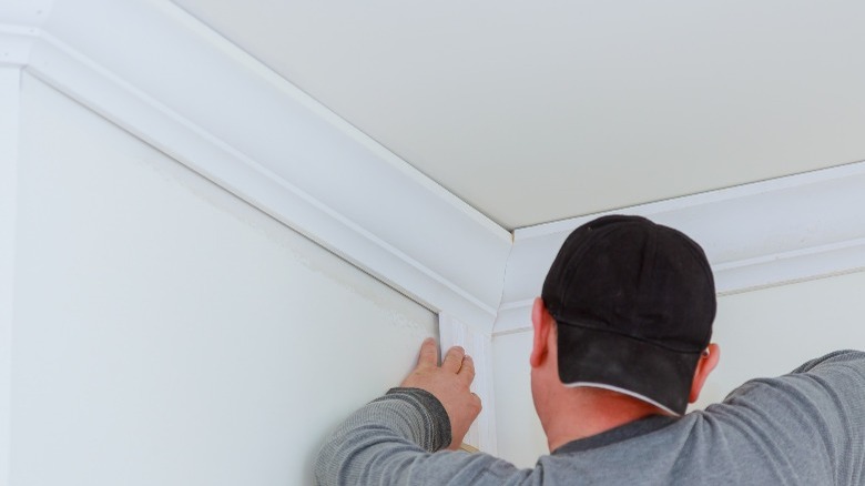 Man in cap installing crown molding