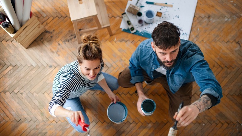 Couple painting a wall