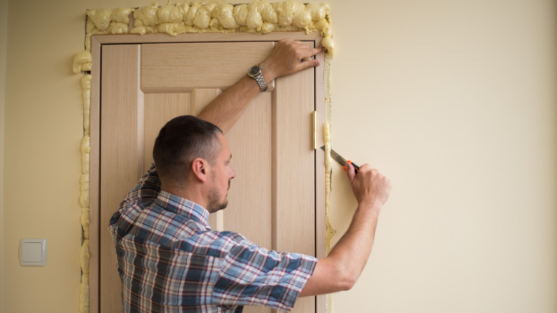 Man using foam around door