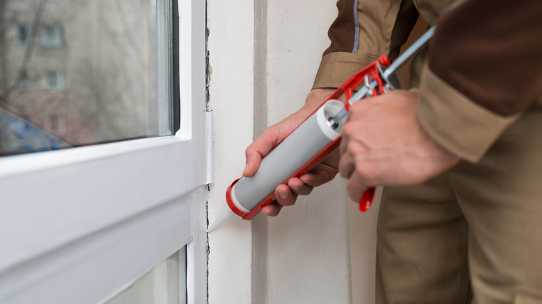 Man caulking window