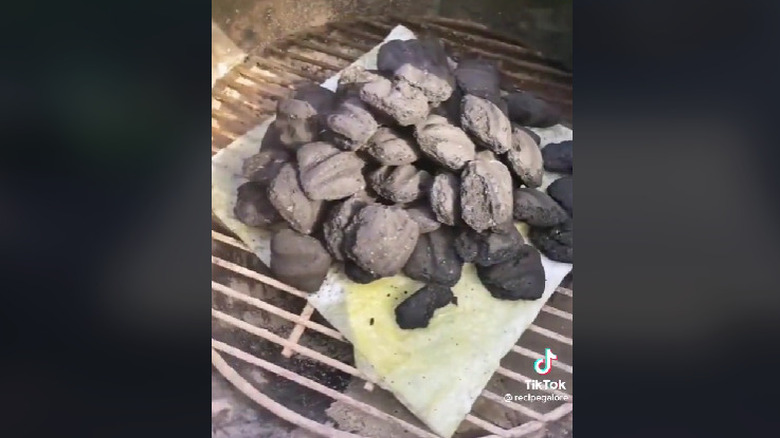 A paper towel under coals in a grill