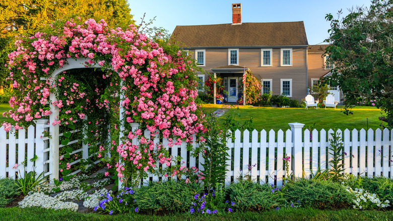 Well-maintained picket fence and archway in front of home