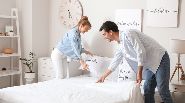 Couple making bed