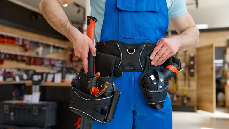 Carpenter reaching into tool belt