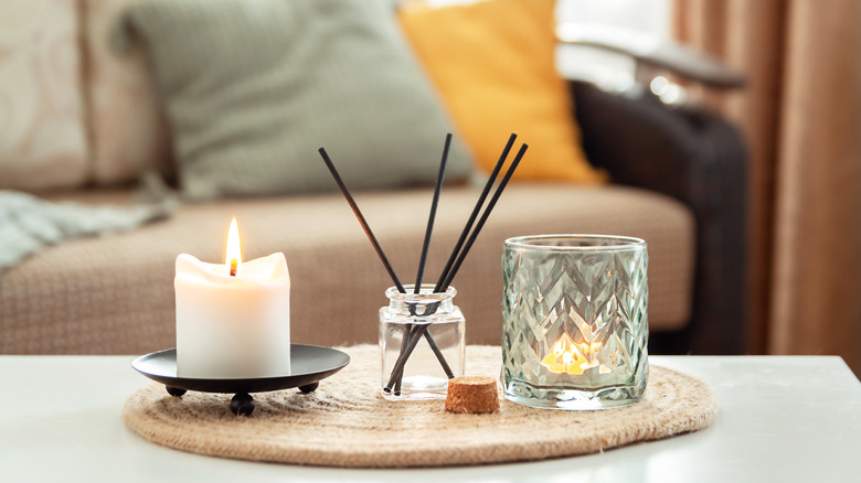 Scented candle, diffuser and tea light on a table