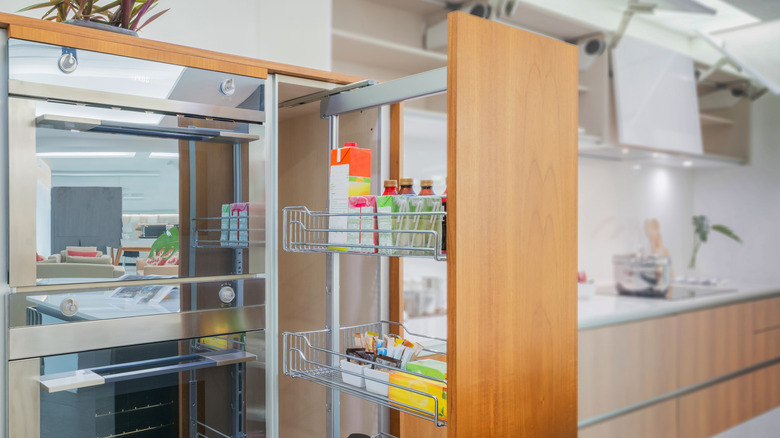 Pull-out pantry cabinet in bright kitchen with built-in appliances