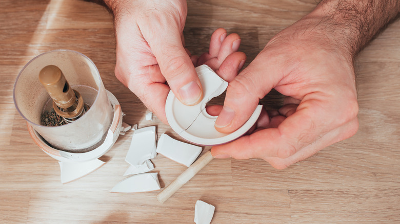 person repairing vase