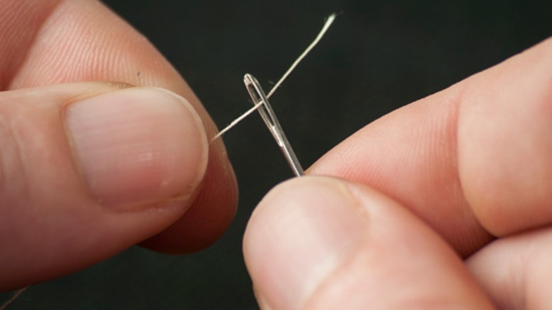 hands threading needle