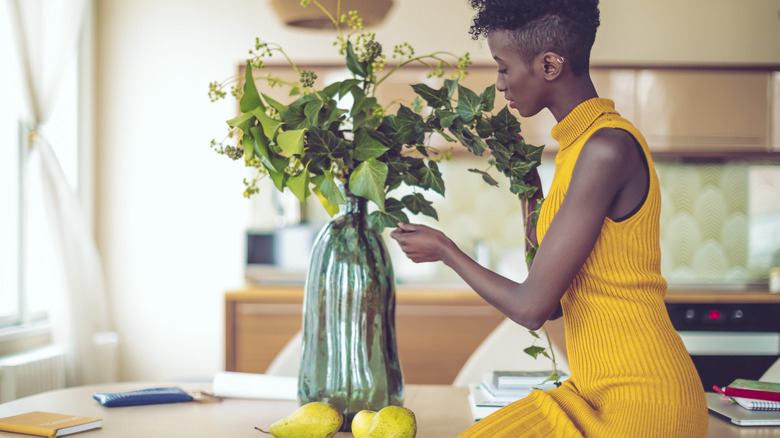 woman arranging flowers in vase