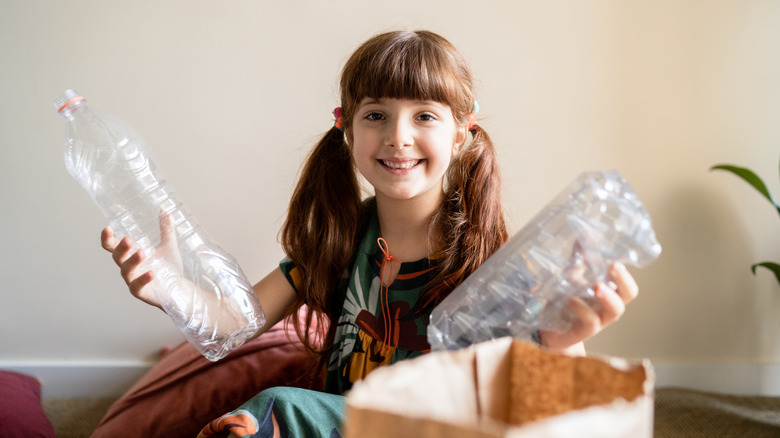 girl holding plastic water bottles