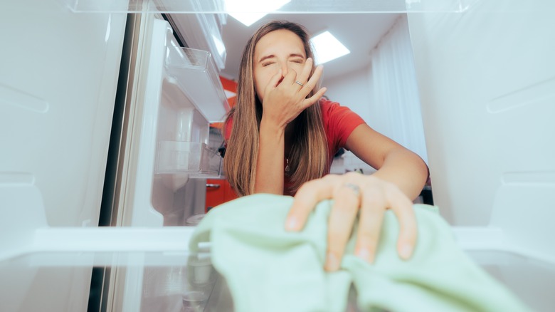 woman cleaning smelly fridge