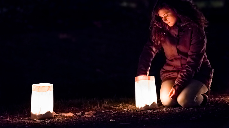 woman lighting luminary candle