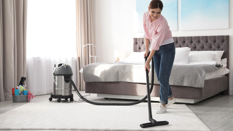Vacuuming the bedroom carpet