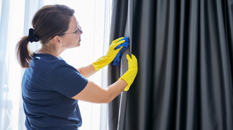 Woman cleaning curtains