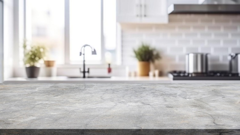 Gray soapstone countertop foregrounds a kitchen