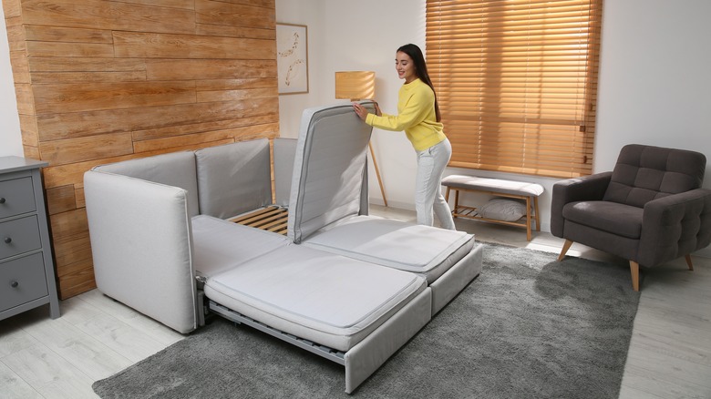 woman unfolding sofa bed