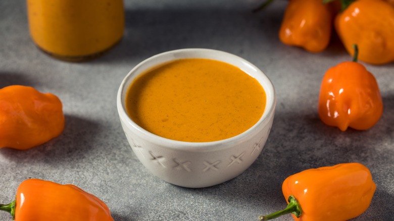 Bowl of orange sauce with peppers