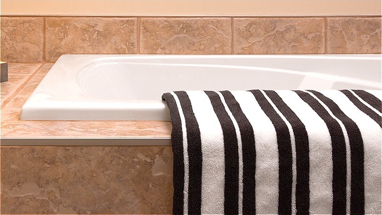 Striped towel slung over bathtub