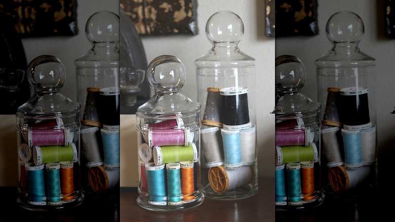 Spools of colorful thread inside apothecary jars