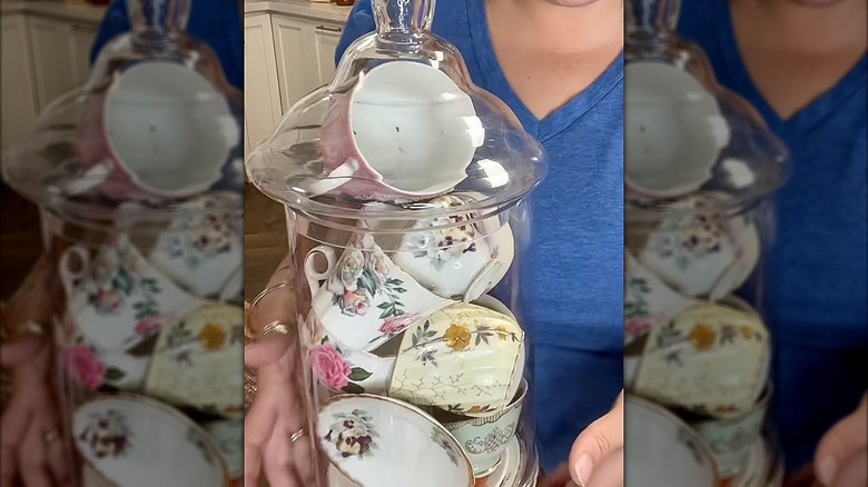 Apothecary jar filled with cups and saucers